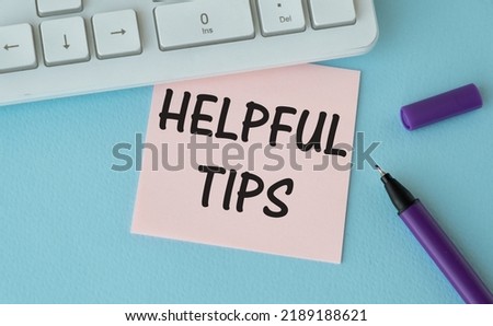Selective focus of pens, watch and notebook written with text HELPFUL TIPS. Business and Education concept.