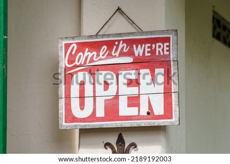 Rustic Open Sign Hanging on the wall of homemade traditional coffeshop or handycraft shop. wodden red we are open sign.