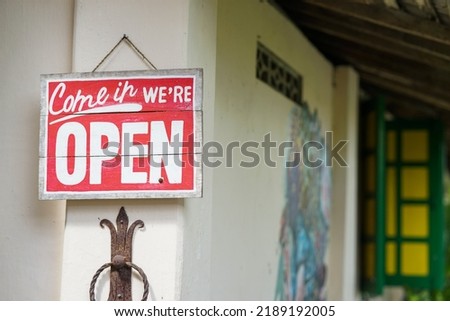 Rustic Open Sign Hanging on the wall of homemade traditional coffeshop or handycraft shop. wodden red we are open sign.