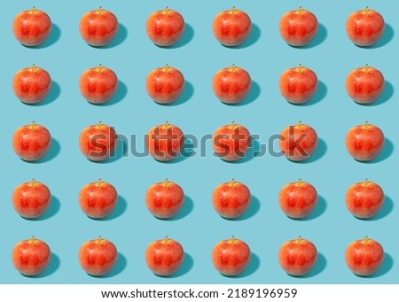 Red apples on green background - creative summer pattern