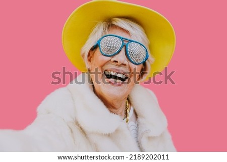 Happy grandmother posing on colored backgrounds. Woman having fun and celebrating