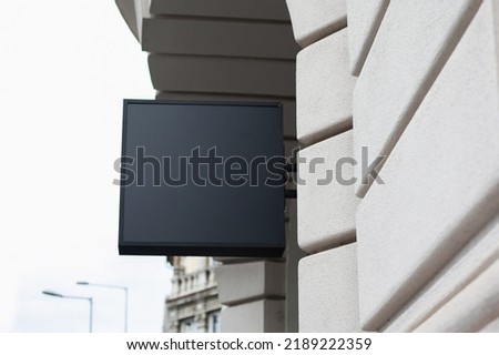 Shop sign building mockup. Black color store mockup for your logo. Minimalist style in modern city.