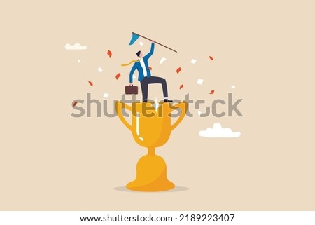 Victory or business achievement, triumph or award winning, accomplishment for leadership success, determination for career success concept, cheerful businessman winner raising flag on winning trophy. Royalty-Free Stock Photo #2189223407