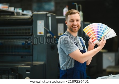 Portrait of worker at control room checking print quality at printing house Royalty-Free Stock Photo #2189226401