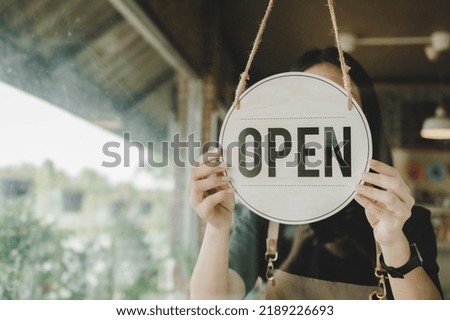 Open. waitress woman turning open sign board reopen after coronavirus quarantine is over in modern cafe coffee shop ready to service, cafe restaurant, small business owner, food and drink concept