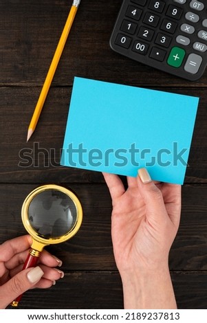 Hands Of Businesswoman With Pastel Color Blank Paper And Stationery Over Wooden Background. Woman Holding Empty Sheet With Copy Space For Branding And Advertisement.