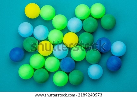 Abstract colored balls background. Multi-colored taw toy scattered on bright paper. Base for design nice backdrop, wallpaper, poster. Noisy surface texture.