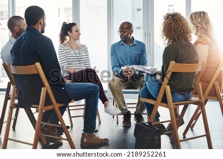A group therapy session with diverse people sharing their sad problems and stories. People sitting in a circle talking about their mental health issues and looking for support, help and counseling Royalty-Free Stock Photo #2189252261
