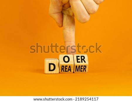 Doer or dreamer symbol. Concept words Doer or dreamer on wooden cubes. Businessman hand. Beautiful orange table orange background. Business and doer or dreamer concept. Copy space. Royalty-Free Stock Photo #2189254117