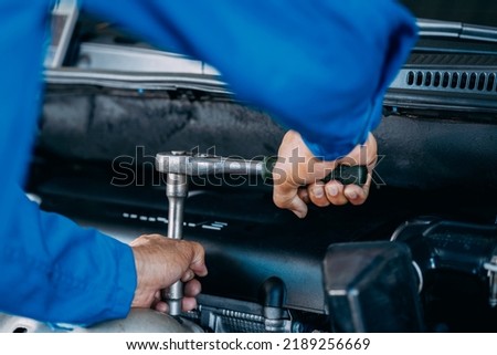 Close up of view Auto mechanic repairman using a socket wrench working engine repair in the garage, change spare part, check the mileage of the car, checking and maintenance service concept. Royalty-Free Stock Photo #2189256669