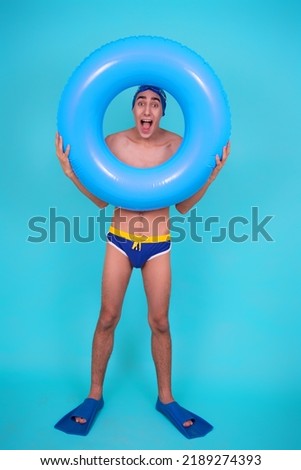 Funny guy with an inflatable ring in the pool.	
