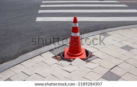 Orange Road Traffic Cone with White Stripes on Street