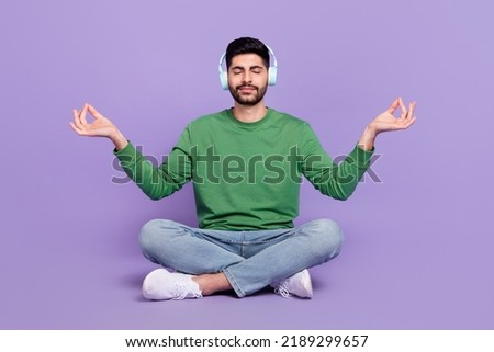 Full length photo of latin arab guy meditate listen classical music lotus pose wear stylish green look isolated on purple color background