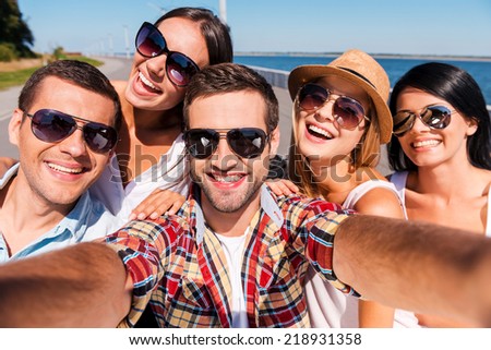 Capturing fun. Five young happy people making selfie and smiling