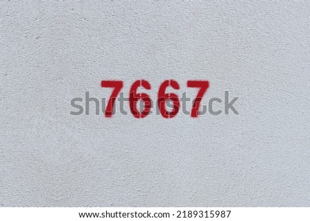 Red Number 7667 on the white wall. Spray paint.
