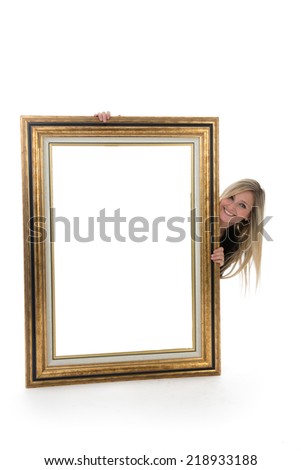 Blond Smiling Woman Peeking Out from Behind Blank Picture Frame in Studio with White Background