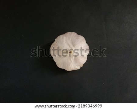 Picture of a head of garlic on a black background.