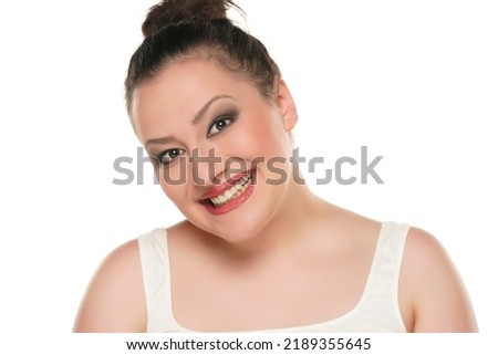 Portrait of a young happy chubby woman with makeup on a white background.