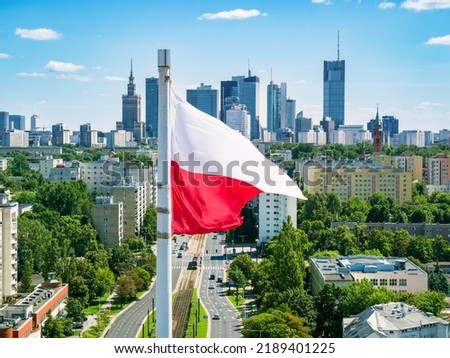 Polish national flag against skyscrapers in Warsaw city center, aerial landscape under blue sky Royalty-Free Stock Photo #2189401225