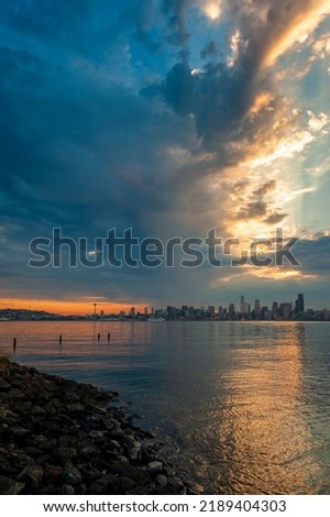 Seattle Skyline During the Morning Blue Hour Seen From West Seattle. Dynamic view of the Seattle cityscape just before dawn with Elliott Bay in the foreground and the waterfront in the distance. 