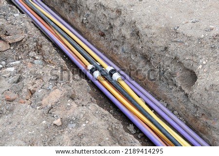 underground electric cable infrastructure installation. Construction site with A lot of communication Cables protected in tubes. electric and high-speed Internet Network cables are buried underground  Royalty-Free Stock Photo #2189414295