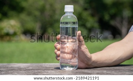 Man drinking water from a plastic bottle.
