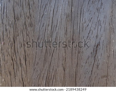 A brownish wooden board with a vertical scratch-like line