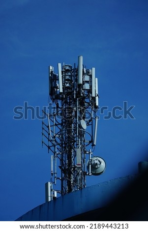 Telecommunication tower of 4G and 5G cellular. Macro Base Station. 5G radio network telecommunication equipment with radio modules and smart antennas mounted on a metal on cloulds sky background. Royalty-Free Stock Photo #2189443213