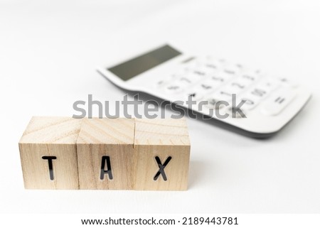 Wooden block tax and calculator. Image of tax calculation