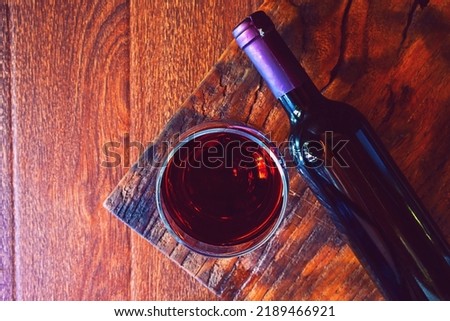 Wine glass and wine bottle on the wooden table