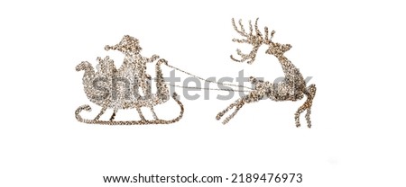 Santa Claus riding on a sleigh pulled by a reindeer. Handmade Santa silhouette made of gold sequins on a white paper background. Template for creating a Christmas or New Year's design