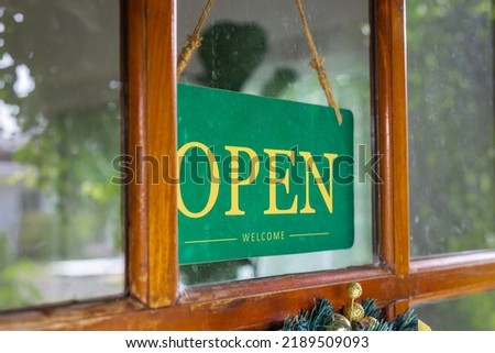 The sign was opened on the wooden door in front of the cafe.