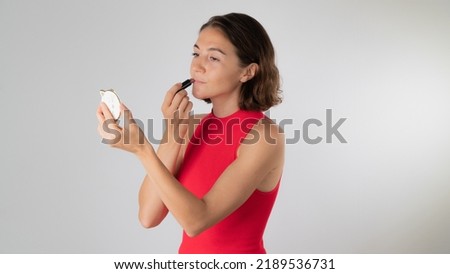 Makeup at home - a woman paints her lips with lipstick. High quality photo