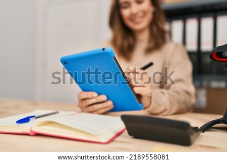 Young woman ecommerce business worker using touchpad at office