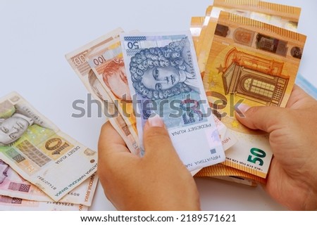 Euro and kunas of various denominations in the hands of a tourist on a white background. Royalty-Free Stock Photo #2189571621