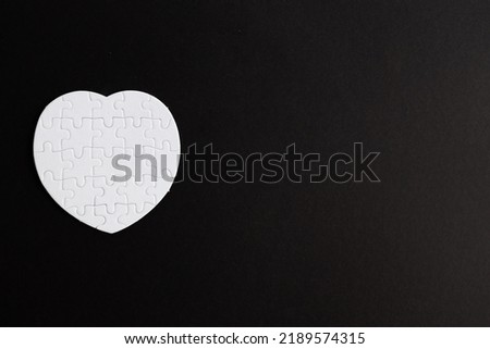 Puzzle heart with one missing piece on black, health care concept