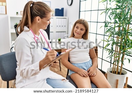 Woman and girl pediatrician and patient having medical consultation at clinic