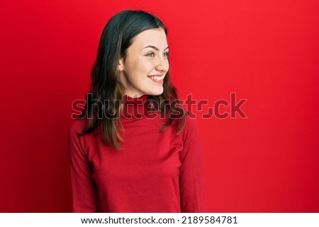 Young brunette woman wearing turtleneck sweater looking to side, relax profile pose with natural face and confident smile. 