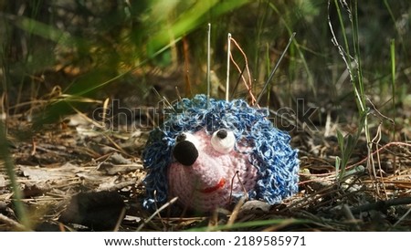 Knitted hedgehog in the forest, Pincushion, knitted toy, hedgehog in the forest, needles in the needle case, blue pincushion Royalty-Free Stock Photo #2189585971