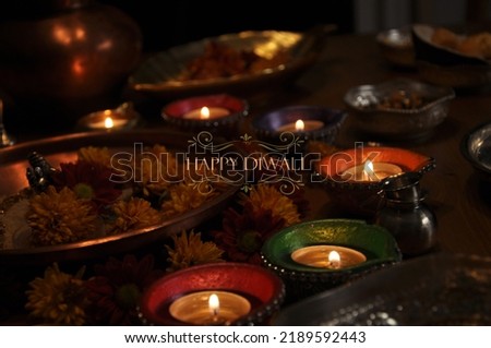 Beautiful, serene oil lamps shining in the calm of the night, surrounded by flowers and silverware.