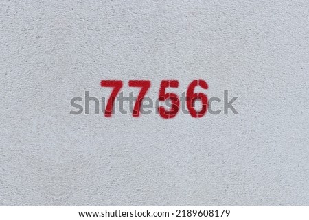 Red Number 7756 on the white wall. Spray paint.
