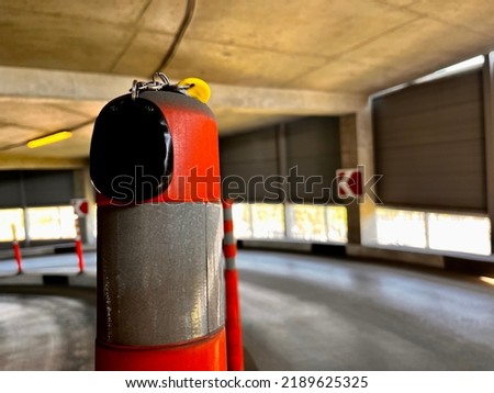 Orange traffic sign in the parking lot. Car keys on the pole