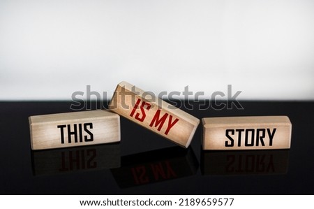 The symbol of my history. Words This is my story written on wooden blocks and white and black background with reflection. Business and my story concept.