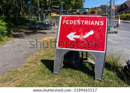 White and red pedestrians keep left sign by roadworks