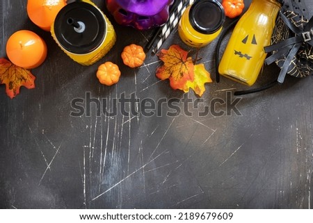 Pumpkin drink on a festive halloween table and Halloween pumpkins, lantern and decoration on dark stone background. Top view flat lay background. Copy space.
