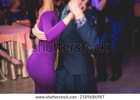 Couples dancing traditional latin argentinian dance milonga in the ballroom, tango salsa bachata kizomba lesson in the red and purple lights, dance festival
 Royalty-Free Stock Photo #2189686987
