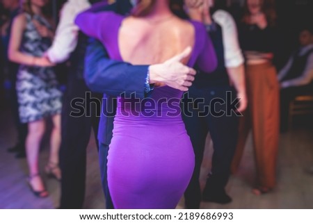 Couples dancing traditional latin argentinian dance milonga in the ballroom, tango salsa bachata kizomba lesson in the red and purple lights, dance festival
 Royalty-Free Stock Photo #2189686993