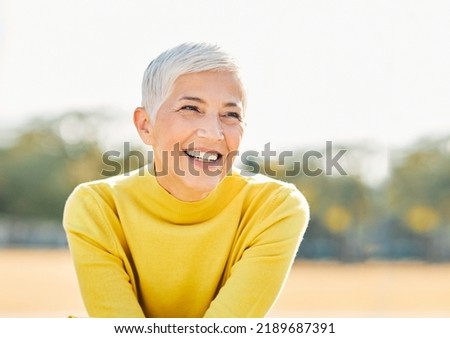 Portrait of an elderly woman outdoors. Happy senior woman in park