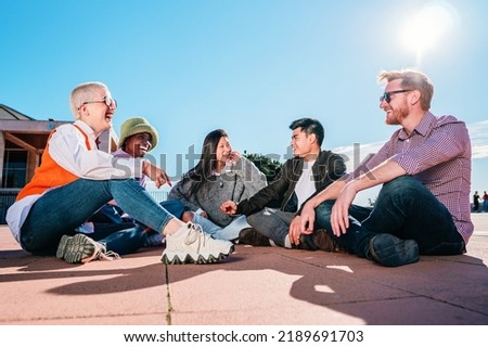 Group of friends sitting on floor laughing and having fun.