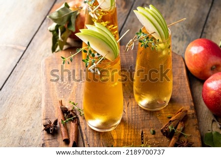 Apple cider mimosa for fall brunch, garnished with apple slices, autumn cocktail or mocktail idea